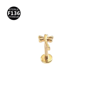 Detailed view of sterile F136 titanium gold dragonfly labret stud and ear cartilage jewelry