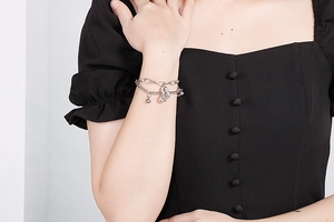 Détail d'un bracelet multicouche en acier inoxydable avec breloques cœur au poignet
