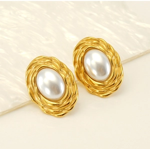 Macro detail of vintage oval stud earrings with pearl center and woven gold steel border
