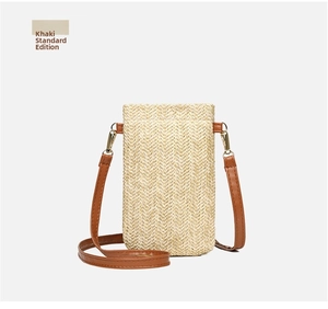Detail of khaki straw woven phone bag with V-shaped pattern and brown leather strap