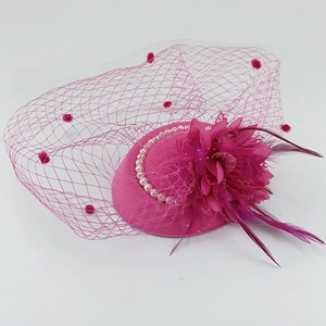 Detailed view of a pink fascinator hat with elegant veil, feathers and pearl bead trim