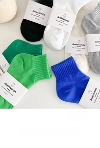 Dettaglio di calzini in cotone colorati con fasce di imballaggio in carta premium