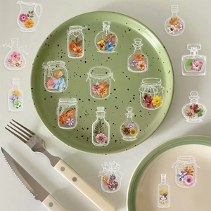 Detailed view of clear floral PET stickers in bottle shapes on table setting decor