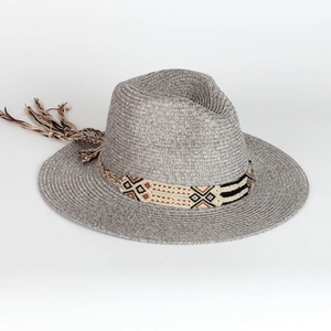 Detail of woven straw Panama hat with ethnic geometric pattern ribbon and long tassels