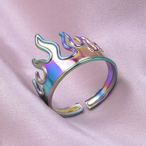 Detailed macro view of the iridescent flame-shaped ring on soft pink silk fabric