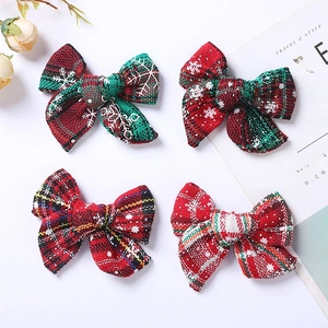 Gros plan de quatre nœuds de Noël avec motifs de flocons rouges et verts sur tissu de lin