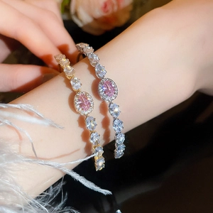 Detail of luxury gold and silver bangles with pink oval gemstones and sparkling crystals