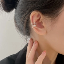 Detail of silver layered crisscross ear cuff showing minimalist metal texture and design
