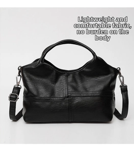 Close-up of black soft leather handbag with lychee texture and cross-stitch detail