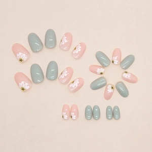Short oval press-on nails in light green and pink with delicate white daisy floral art