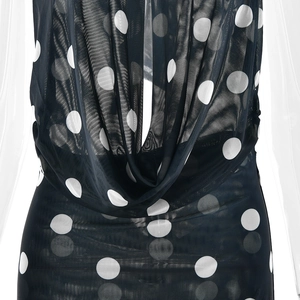 Détail du décolleté drapé sur une robe en tulle noir à pois avec une texture transparente