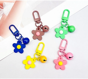 Detail of colorful matte flower charms with matching bells and lobster clasps in five colors