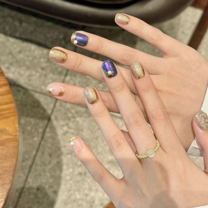 Short square press-on nails with gold glitter, purple gradient, and pearl details