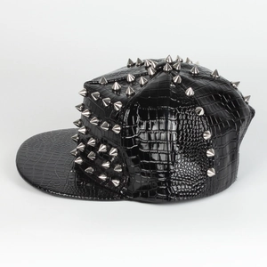 Detail of black faux crocodile leather punk cap with sharp silver metal rivets