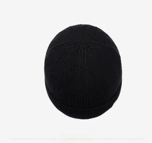 Top view of a black ribbed knit beanie showing the hexagonal crown stitching detail