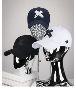 Stack of casual baseball caps with embroidered X logo in navy blue, black and white colors