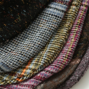Close-up of thick knit faux cashmere fabric showing colorful plaid and tweed textures