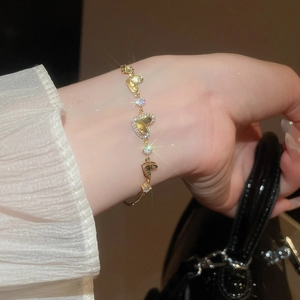 Close-up of gold heart bracelet with zircon pavé and adjustable pull-clasp on wrist