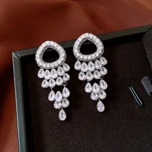 Detail of luxury silver fringe earrings with cubic zirconia on black velvet and silk