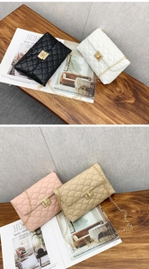 Vue détaillée de quatre sacs à chaîne texturés en noir, blanc, rose et kaki sur table