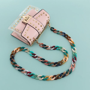 Pink studded crossbody bag with colorful acrylic chain and gold metal rivets