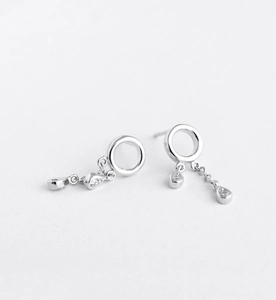 Macro detail of silver dangle earrings with a crystal circle and water drop tassels