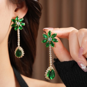 Close-up of vintage emerald green waterdrop flower earrings with zircon in gold plating