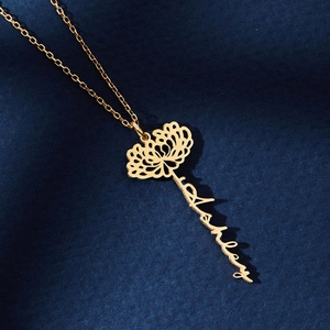 Close-up of gold customized necklace with floral element and script name pendant