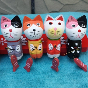 Detailansicht von vier handgefertigten Angelkatzen-Figuren aus Holz mit bunten Mustern
