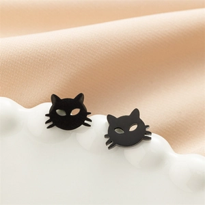 Macro view of cute black cat stud earrings with matte finish on a ceramic tray