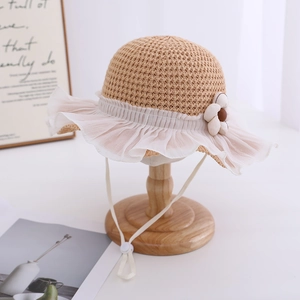 Close-up of girls straw sun hat featuring lace mesh brim, floral accent and chin strap