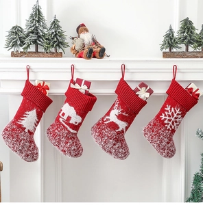 Detailed view of four red knitted Christmas stockings with festive white patterns on a mantel