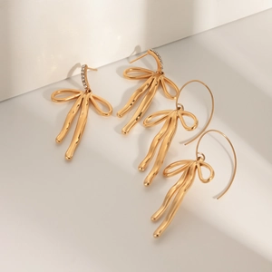 Detailed view of 18k gold plated bow earrings with zircon stones and hook design