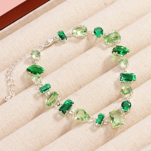 Detailed shot of silver bracelet with mixed green zircons in various shapes
