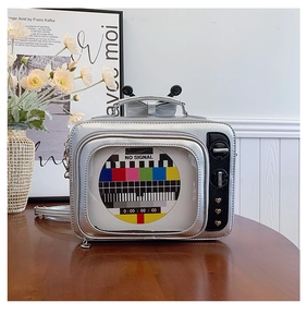 Macro shot of silver retro TV shaped bag with heart rivets and decorative antennas