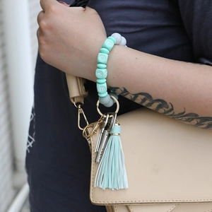 Wristlet keychain with mint green silicone beads and LOVE letters worn on a wrist