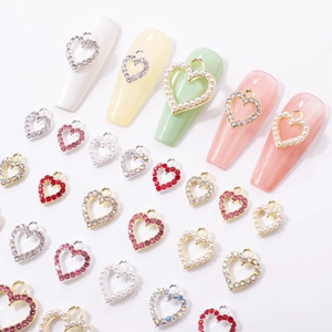 Y2K heart nail charms set with rhinestones and pearls on a clean white background