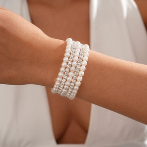 Detail of multilayer bracelet featuring white faux pearls and shimmering rhinestone bands