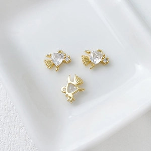 Detailed macro view of three 14k gold plated bird charms with sparkling clear crystals