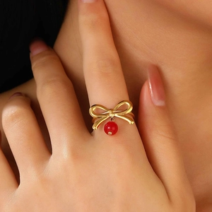 Eleganter goldener Schleifenring mit feinem rotem Perlenanhänger aus Edelstahlband