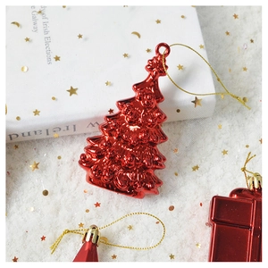 Macro detail of a red metallic Christmas tree hanging ornament with a gold cord for holiday decor