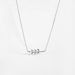 Close-up of a silver leaf pendant necklace with fine chain detail on white background