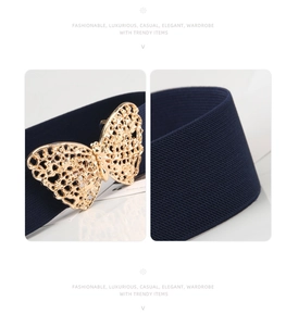 Detail of navy blue elastic waist belt featuring a gold butterfly buckle and textured strap