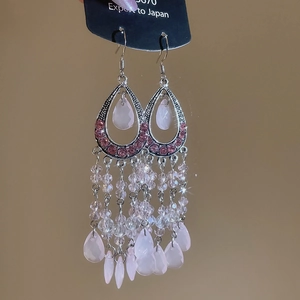 Detail of pink crystal teardrop earrings with beaded tassels on silver alloy base