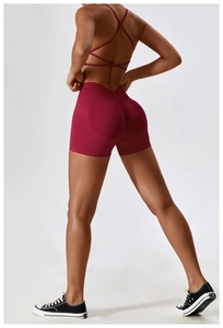 Detail view of burgundy yoga set with cross-back sports bra and ruched butt-lifting shorts