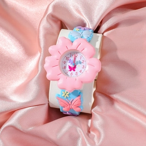 Pink floral watch face and blue butterfly silicone strap on pink silk fabric detail