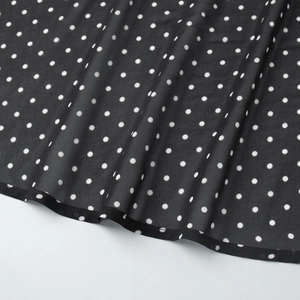 Detail of polka dot dress fabric showing high-quality stitching and lightweight texture