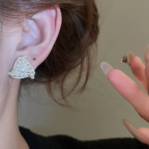 Close-up of elegant triangle pearl stud earring with pavé zircon details on model ear