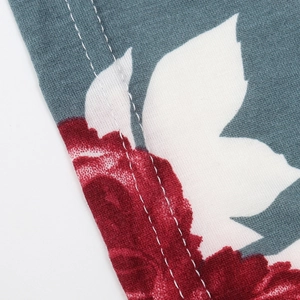 Macro shot of red floral print fabric with durable double-row white stitching detail