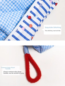 Detail showing checkered fabric texture, neat zipper stitching, and red plush carry handle